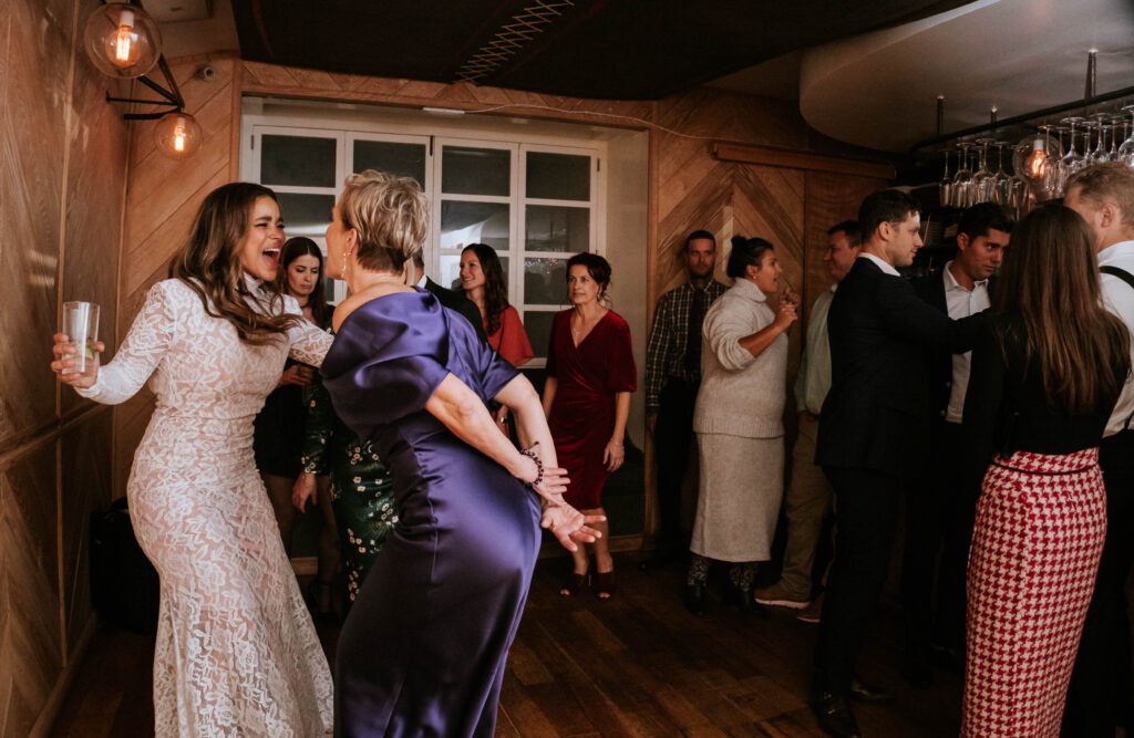 Bride and mom enjoying dancing moments at the East Pole intimate wedding reception.