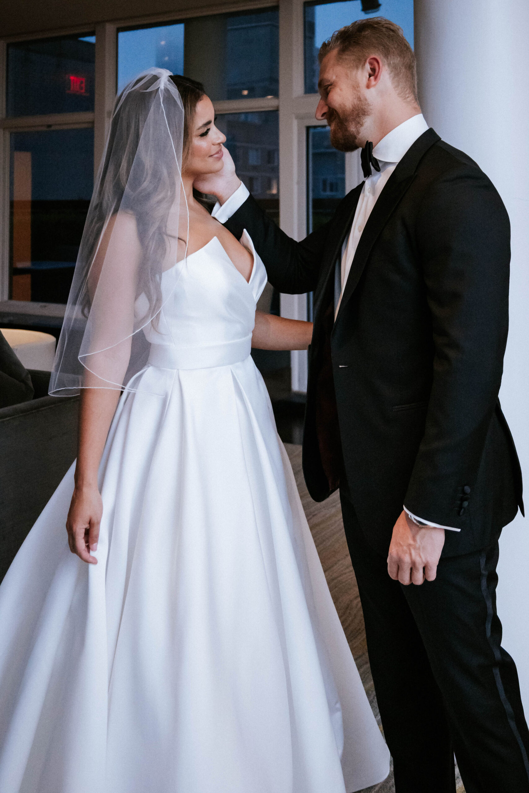 Simple moment between wedding couple as groom touches her face.