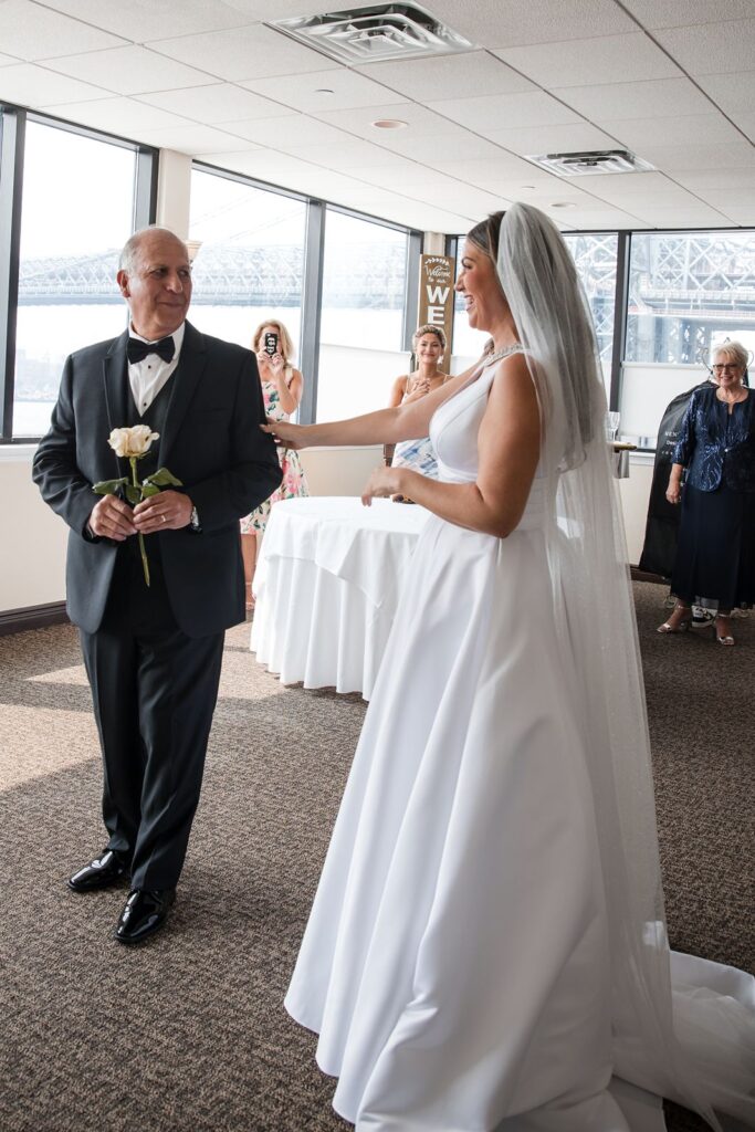 Bride and father's first look moment as immediate family looks on.