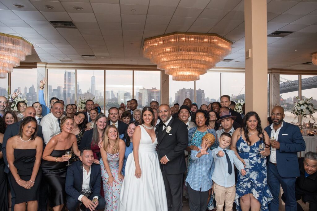 Group picture of bride and groom with guests in Giando on the Water, city views can be appreciated.