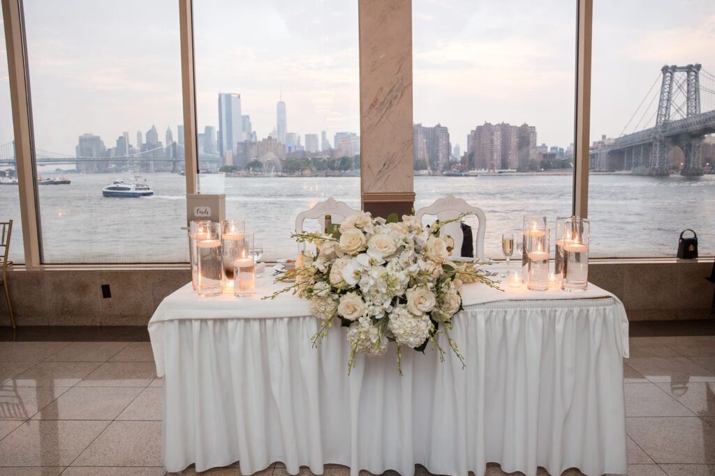 Sweatheart table at Giando on the water placed in the glass wall, Freedom Tower and the Williamsburg Bridge clearly seen.