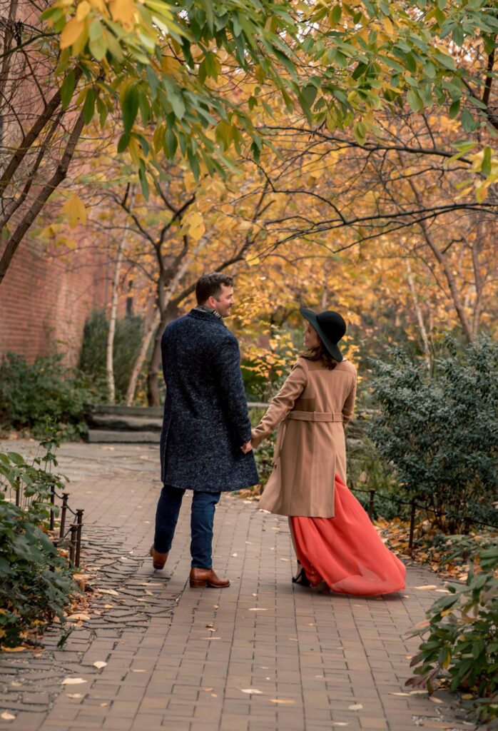 Candid Engagement of couple strolling through the Max Family Garden with the trees showing off their autumn colors.